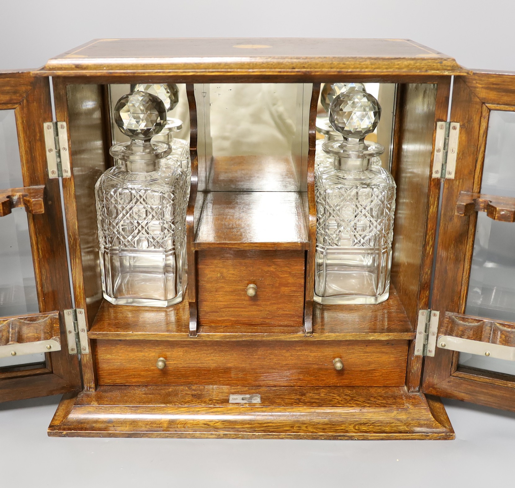 An Edwardian inlaid oak drinks cabinet, with two cut glass decanters, 40 cms wide x 37 cms high